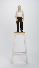 Figura femenina de pie con pantalon café
