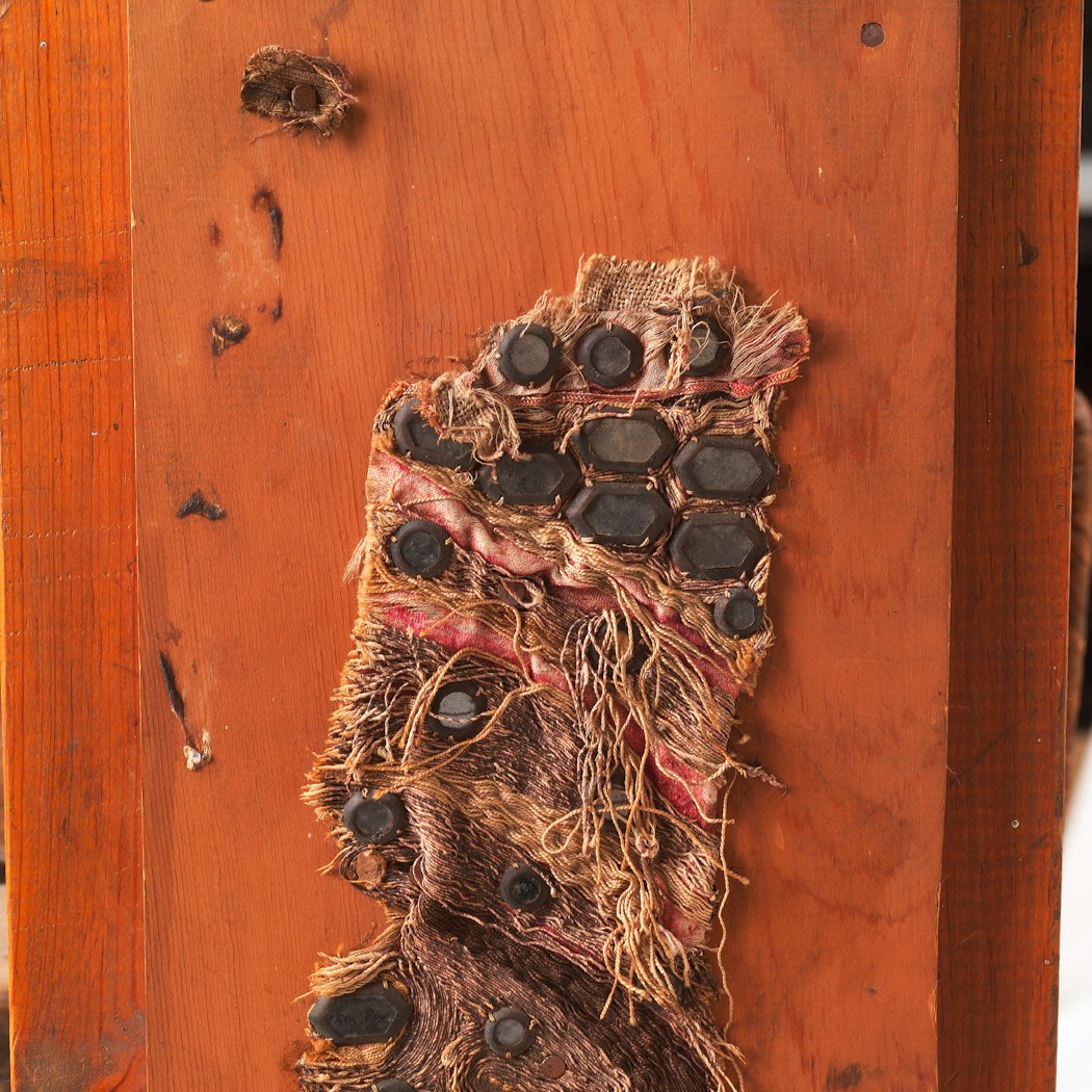 frayed fabric nailed to one side