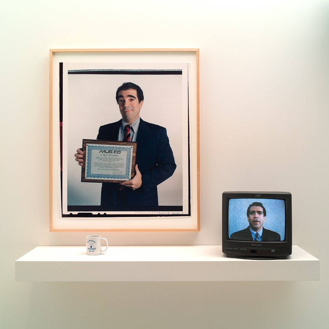 video still shows head & shoulder view of man looking directly into camera