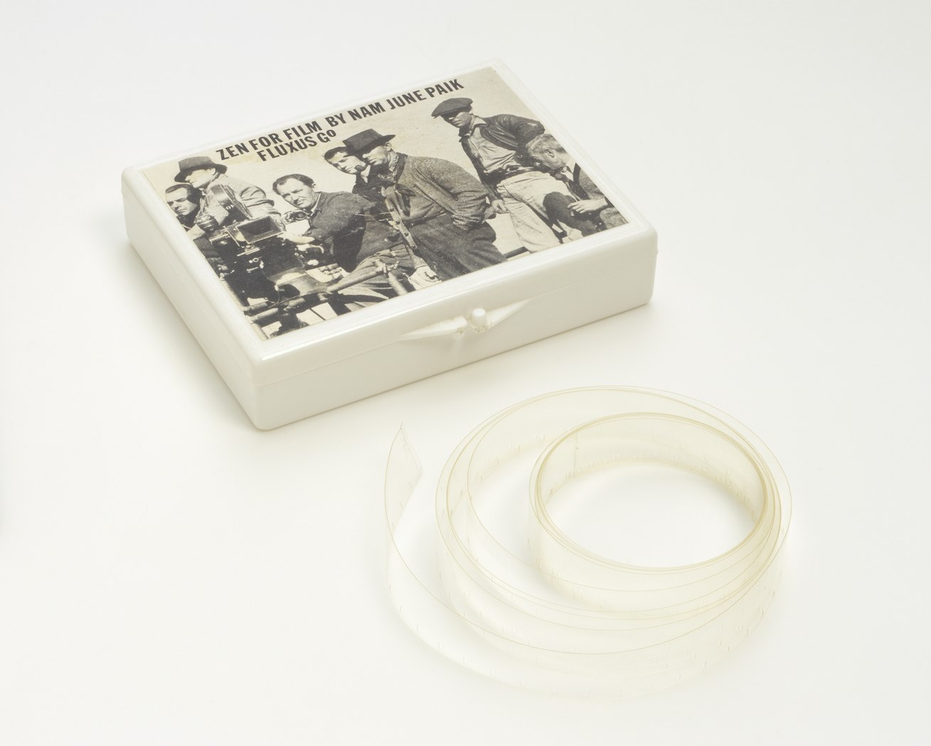 box at angle showing top; film sits coiled below.