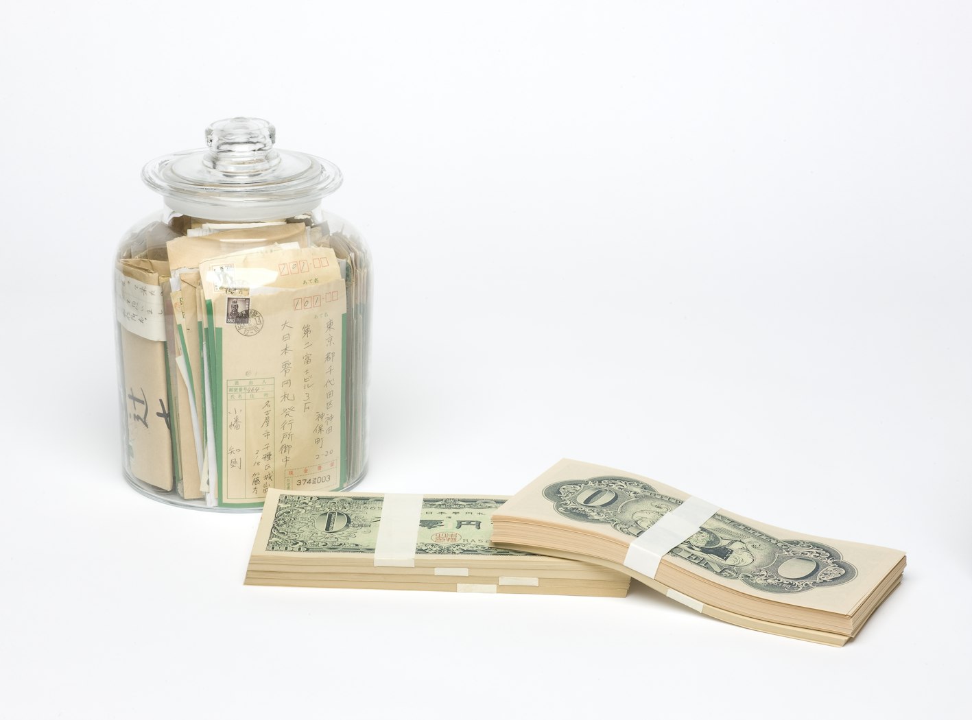 Jar closed, 2 stacks of money laid out